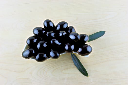 Black Olives with leaves on a white background