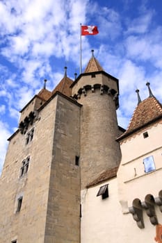 View of one tower with swiss flag of the old castle by cloudy day, Aigle, Vaud, Switzerland