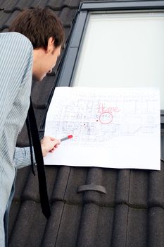 young man architect presenting a project against the background of the roof and windows