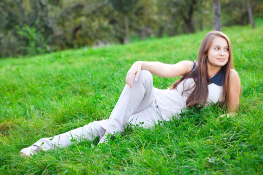 beautiful young woman lying on green grass