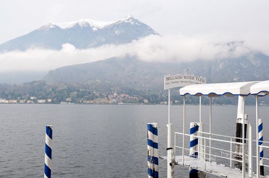 Bellagio water taxi pier and winter view of Lago Como. Blue mood.