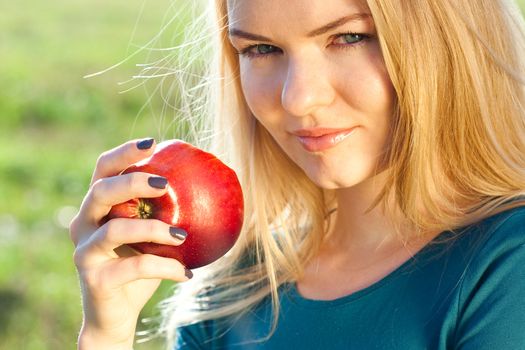 portrait of a beautiful young woman with apple  outdoor