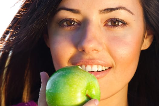 portrait of a beautiful young woman with apple  outdoor