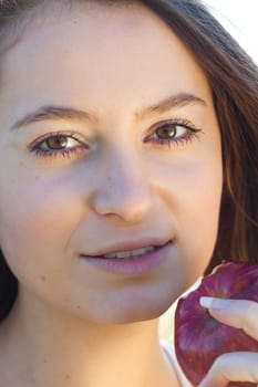 portrait of a beautiful young woman with apple  outdoor