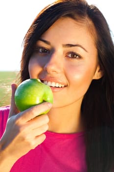 portrait of a beautiful young woman with apple  outdoor