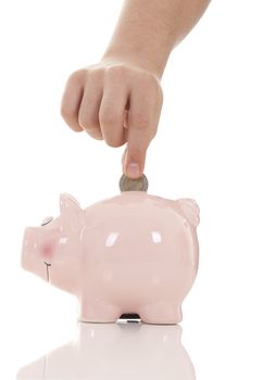 Savings - Piggy bank and hand with coin