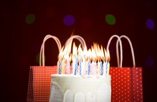 happy birthday cake shot on a red blurred background with candles