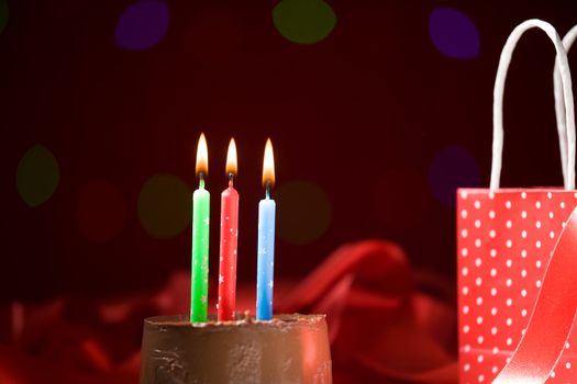 happy birthday cake shot on a red blurred background with candles