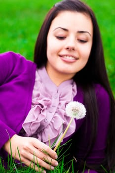 portrait of a beautiful young woman with dandelion