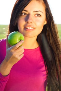 portrait of a beautiful young woman with apple  outdoor