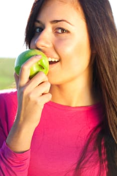 portrait of a beautiful young woman with apple  outdoor