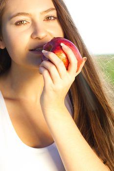 portrait of a beautiful young woman with apple  outdoor