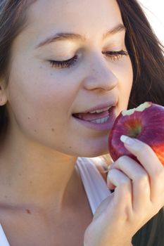 portrait of a beautiful young woman with apple  outdoor