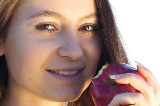 portrait of a beautiful young woman with apple  outdoor