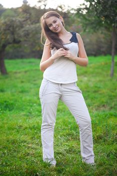 beautiful young woman standing on green grass