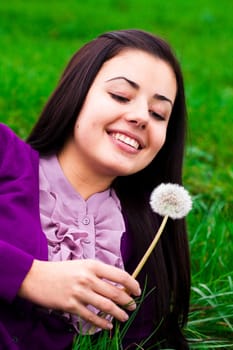 portrait of a beautiful young woman with dandelion