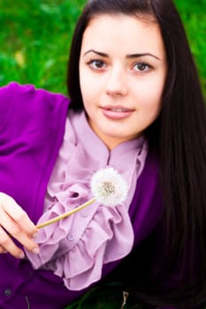 portrait of a beautiful young woman with dandelion