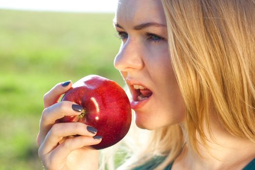 portrait of a beautiful young woman with apple  outdoor