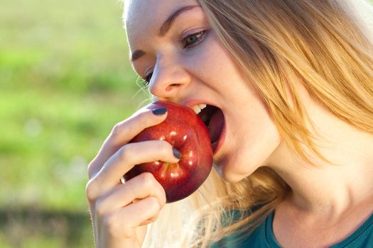 portrait of a beautiful young woman with apple  outdoor