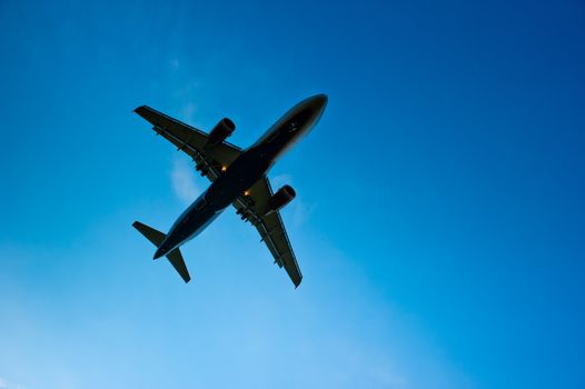 Airliner silhouette against the blue sky