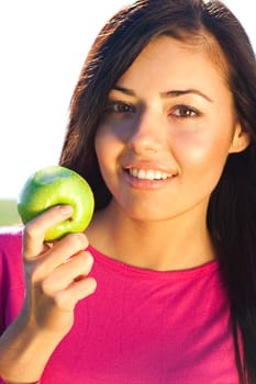 portrait of a beautiful young woman with apple  outdoor