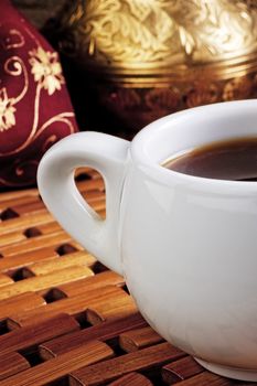 White cup of coffee on a wooden stand