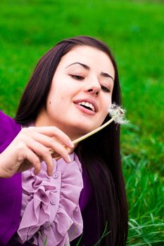 portrait of a beautiful young woman with dandelion