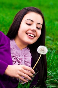 portrait of a beautiful young woman with dandelion