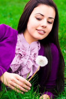 portrait of a beautiful young woman with dandelion