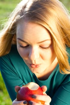 portrait of a beautiful young woman with apple  outdoor