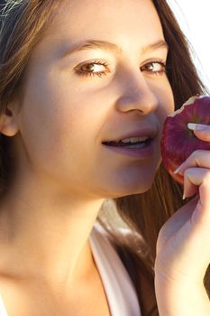 portrait of a beautiful young woman with apple  outdoor