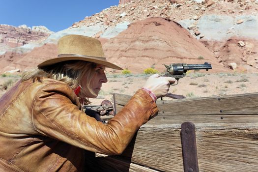 cowgirl with a gun in the hand, ready to shoot