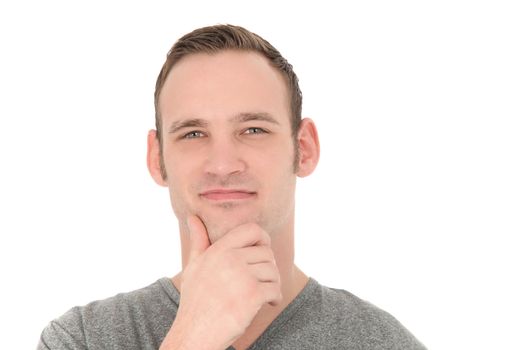 Thoughtful young man looking directly at the camera with his hand to his chin isolated on white