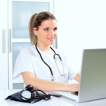 beautiful young woman doctor in hospital with computer