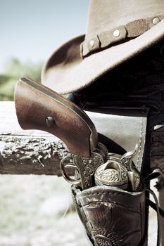 crop of cowboy gun and hat outdoor under sunlight