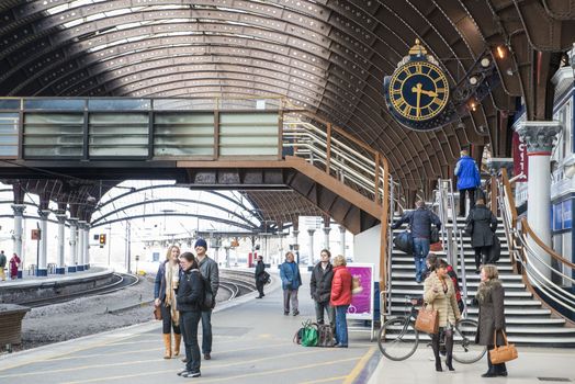 YORK, UK - MARCH 31: Passengers at platform in York Railway Station. Inaugurated in 1877 and bombed during WW2, it is one of the most important railway junctions in the British network. March 31, 2013 in York.
