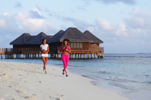 Fitness sport women running on beach in morning