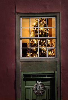 Christmas tree seen from outside of an old house window