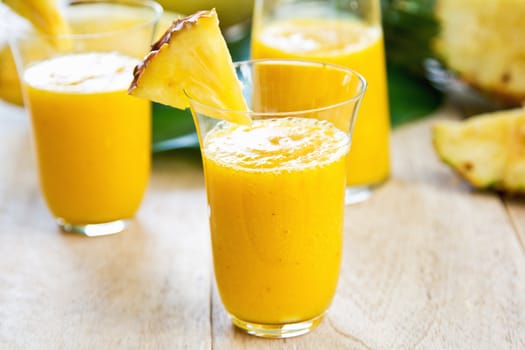 Mango with pineapple smoothie in jug and glasses