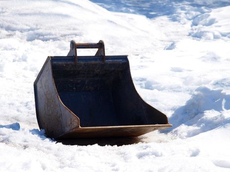 Shovel of a digging machine, isolated in snow