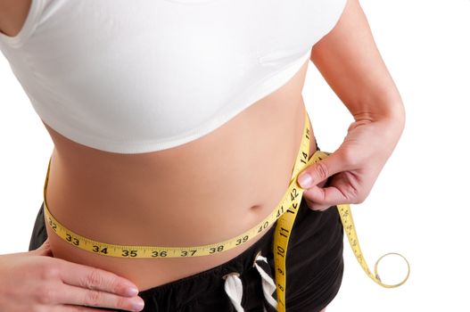 Woman measuring her waist with a yellow measuring tape, isolated in white