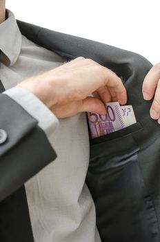 Man putting money in the inner pocket of his jacket. Concept of bribery and corruption.