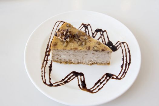 Walnut Cheesecake Slice with Dark Chocolate Drizzle on White Plate