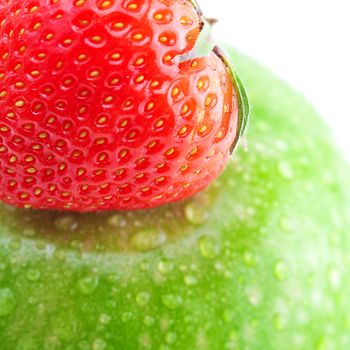 big green apple with water drops and strawberries isolated on white