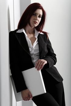 Professional business woman holding a white laptop at work