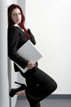 Professional business woman holding a white laptop at work
