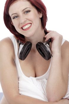 Attractive young woman listening to music at home on her bed