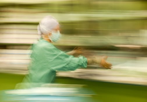 Abstract, blurred figure of nurse runing busy during operation