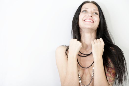 Attractive young woman leaning against a wall in underwear covering her chest with arms.