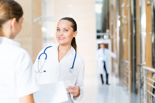 two doctors talking in the lobby of the hospital, sitting on the couch